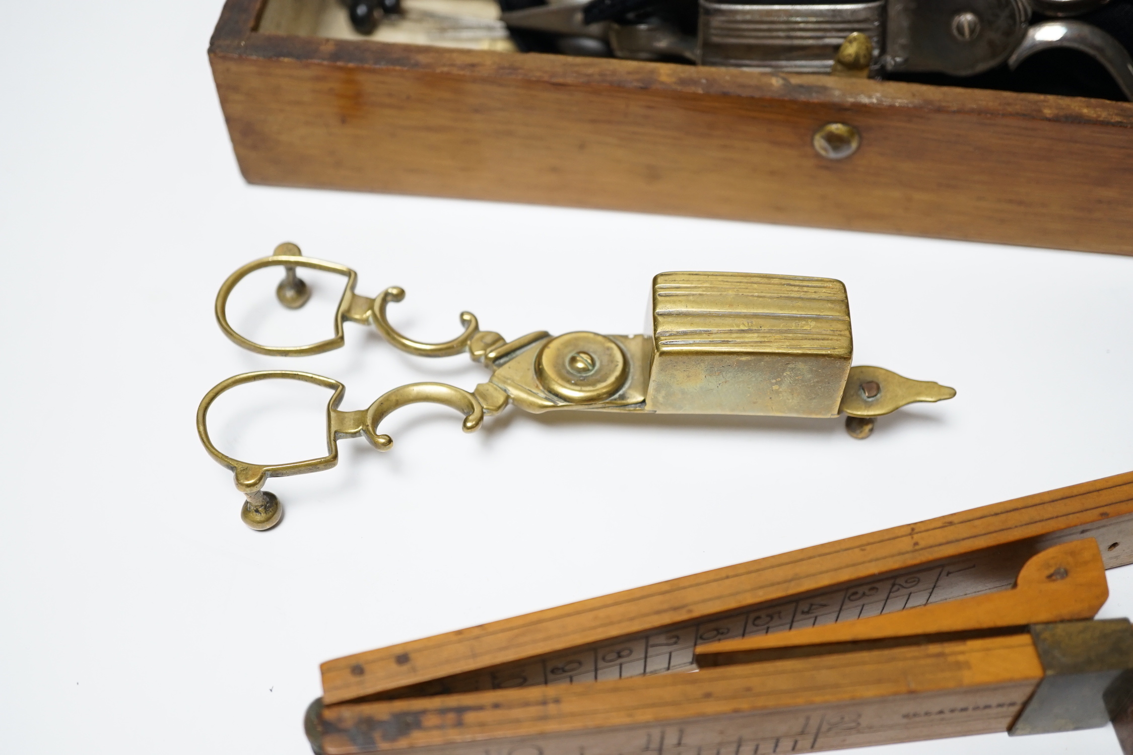 A glove box containing a boxwood foot-measure, two candle snuffers, a silver teaspoon etc